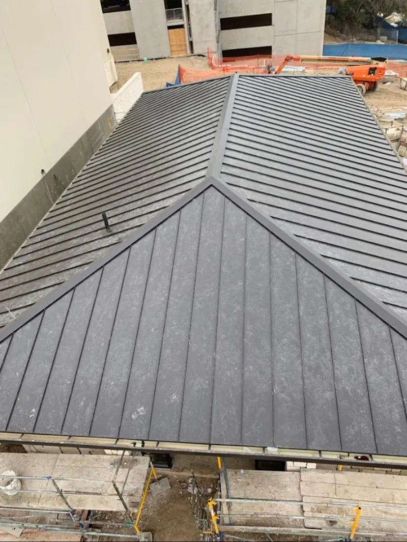 Commercial metal roof construction with crane equipment in Randolph